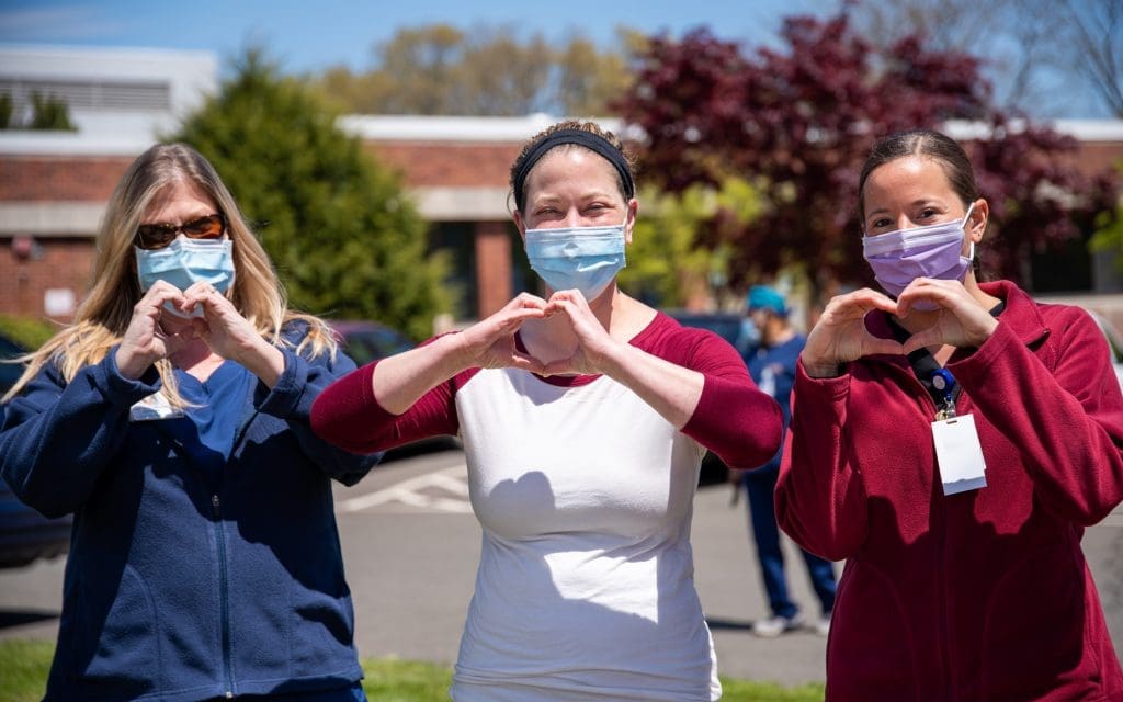 Care team making hearts with their hands. Aster Care provides care at home services in Portsmouth & the surrounding area for people with lifelong conditions & dementia.